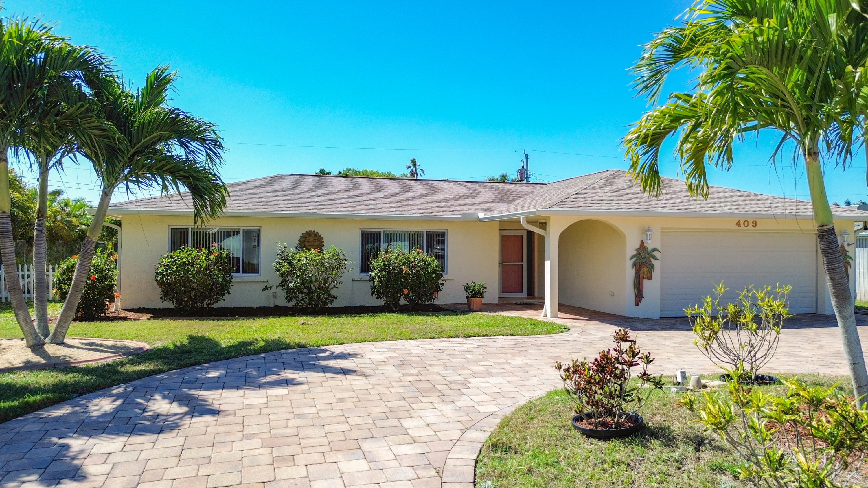 409 Surf Road Melbourne Beach, FL 32951 - Photo 2 of 34 a front view of a house with a yard