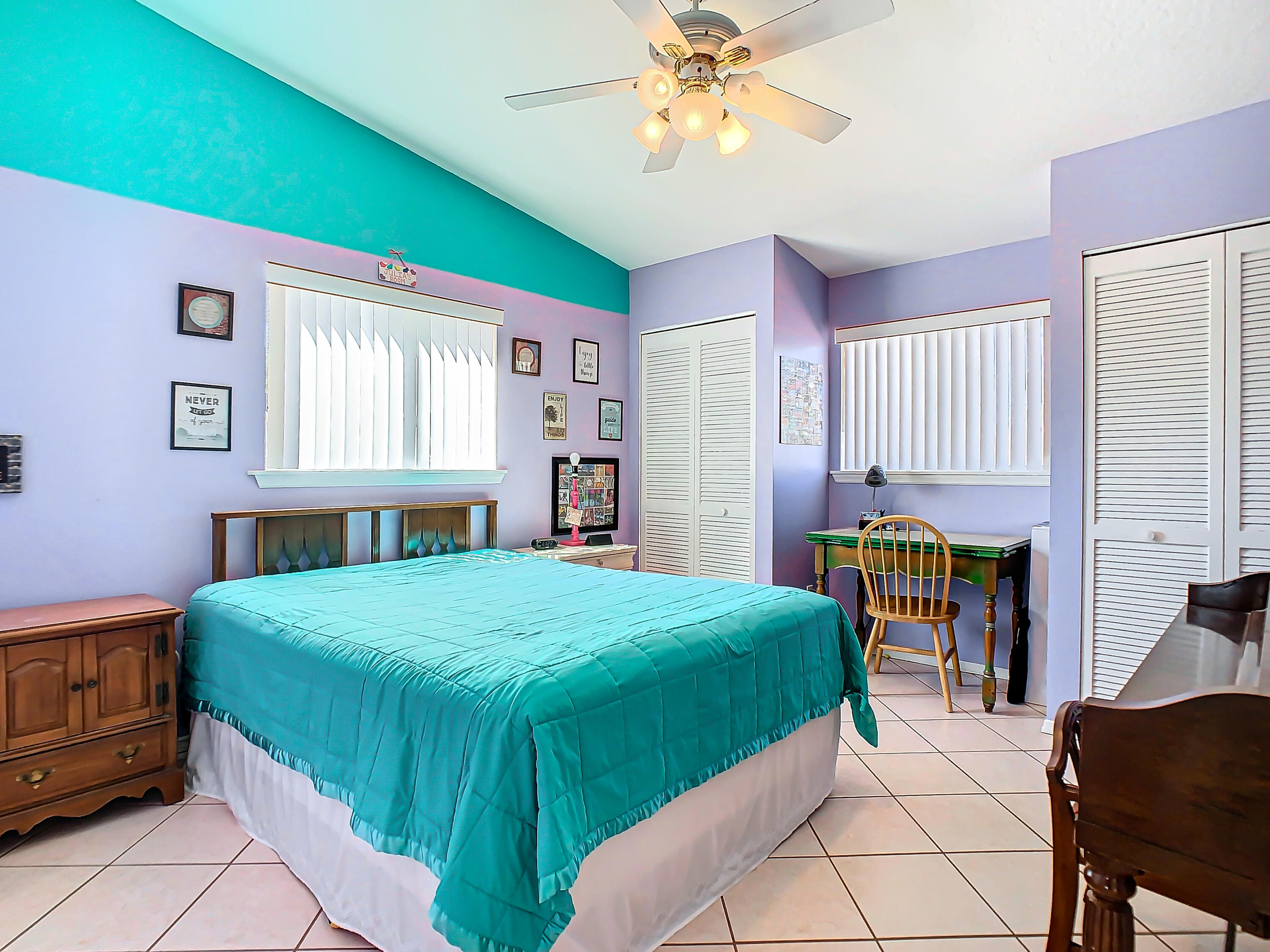 409 Surf Road Melbourne Beach, FL 32951 - Photo 21 of 34 a bedroom with a bed and a chandelier