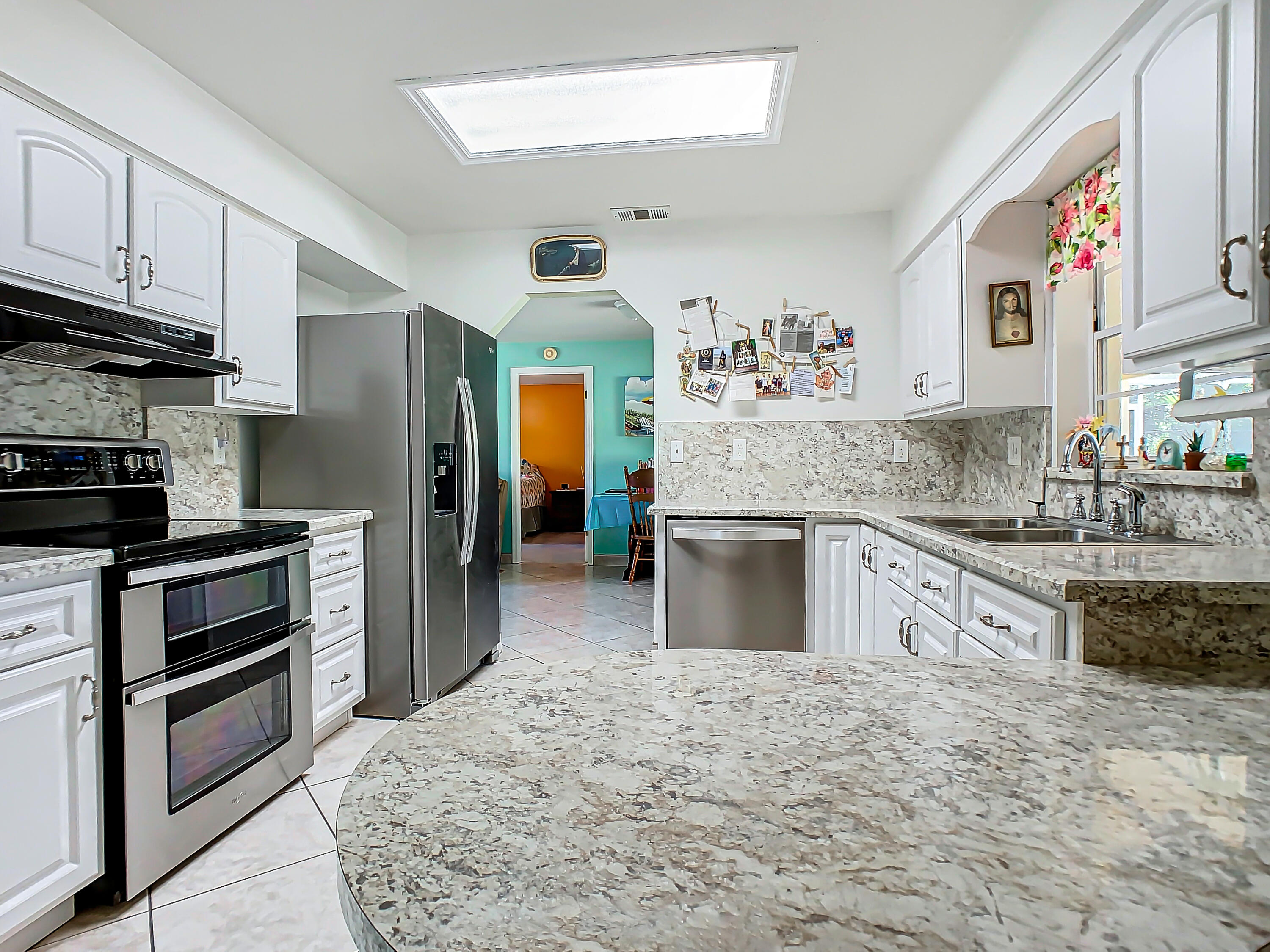 409 Surf Road Melbourne Beach, FL 32951 - Photo 10 of 34 a kitchen with stainless steel appliances kitchen island granite countertop a refrigerator and a stove top oven