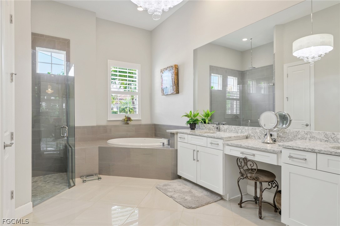 9345 Tulipano Terrace Naples, FL 34119 - Photo 19 of 50 a spacious bathroom with a granite countertop sink mirror and a bathtub