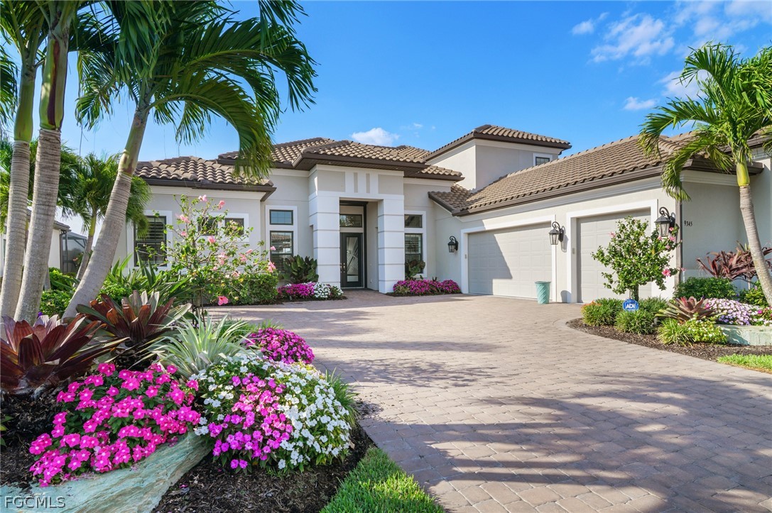 9345 Tulipano Terrace Naples, FL 34119 - Photo 2 of 50 a front view of house and yard with beautiful flowers