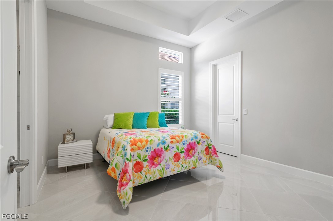 9345 Tulipano Terrace Naples, FL 34119 - Photo 21 of 50 a bedroom with a bed and a table
