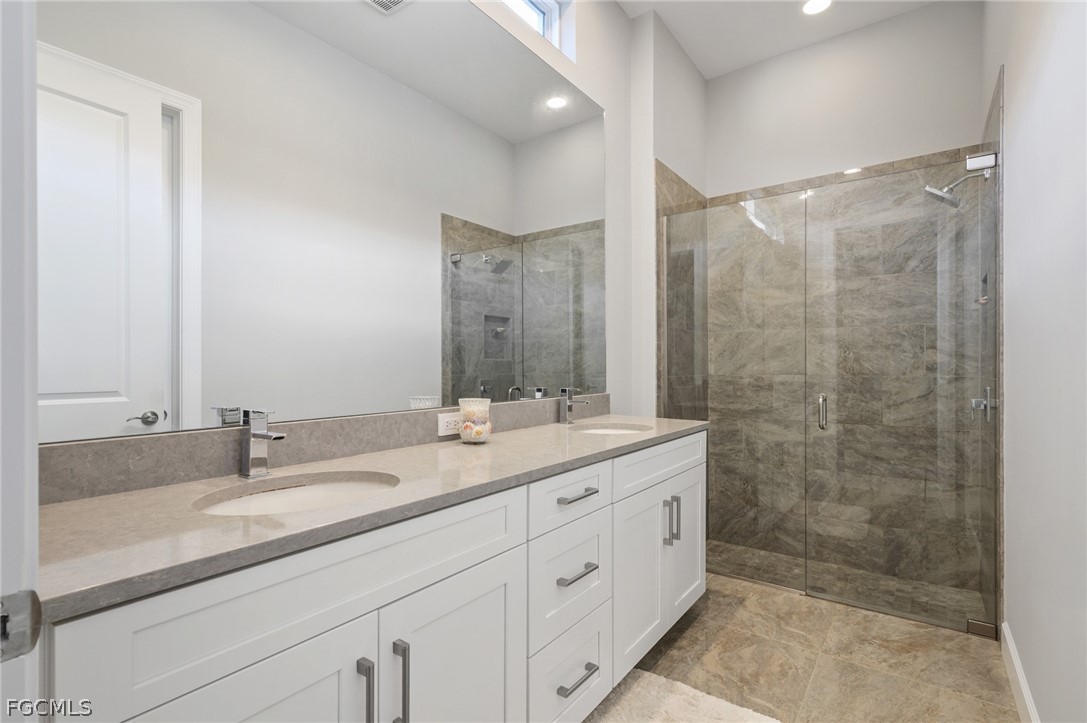 9345 Tulipano Terrace Naples, FL 34119 - Photo 26 of 50 a bathroom with a granite countertop sink mirror and double