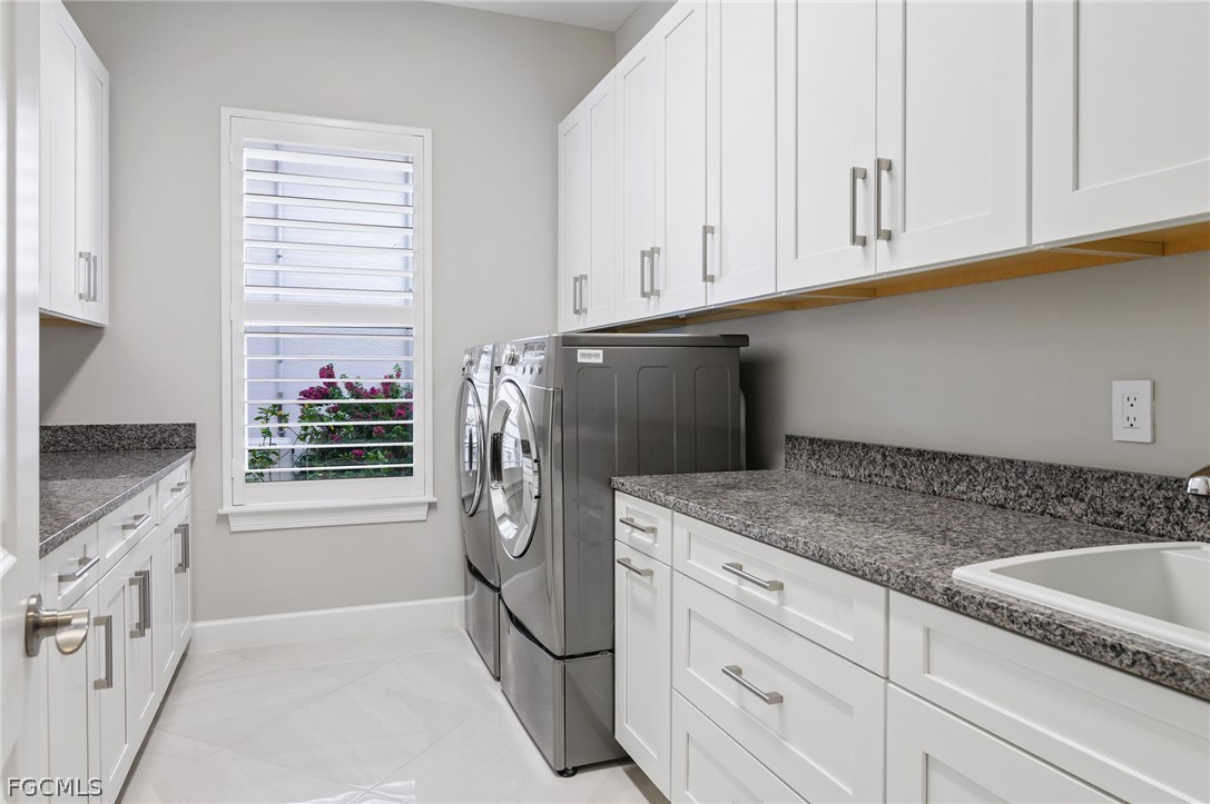 9345 Tulipano Terrace Naples, FL 34119 - Photo 28 of 50 a kitchen with stainless steel appliances granite countertop a sink and a refrigerator