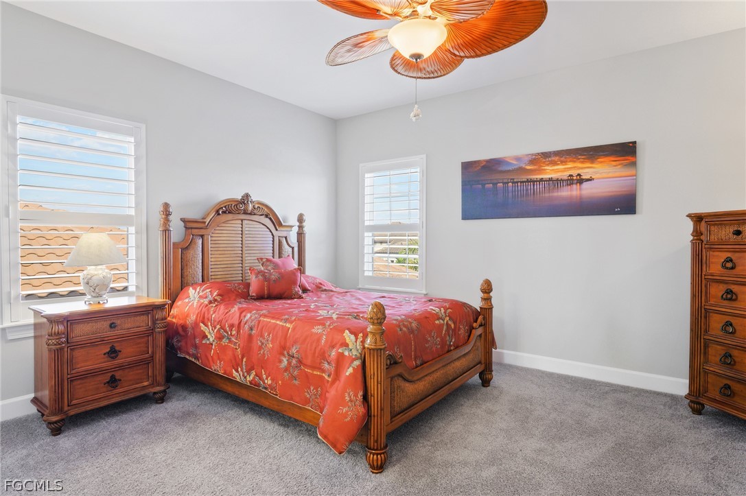 9345 Tulipano Terrace Naples, FL 34119 - Photo 35 of 50 a bedroom with a bed and a chandelier