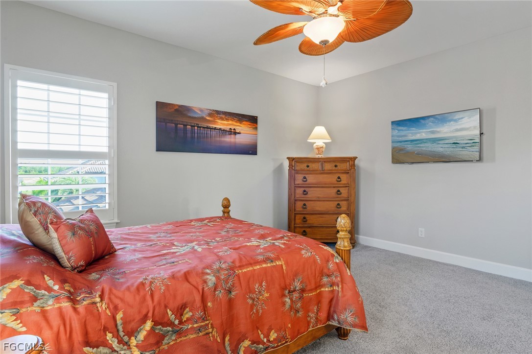 9345 Tulipano Terrace Naples, FL 34119 - Photo 36 of 50 a bedroom with a bed and a chandelier