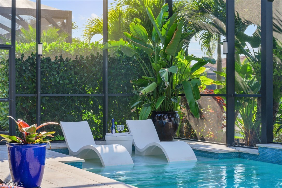 9345 Tulipano Terrace Naples, FL 34119 - Photo 43 of 50 a view of a chairs and table in patio with swimming pool