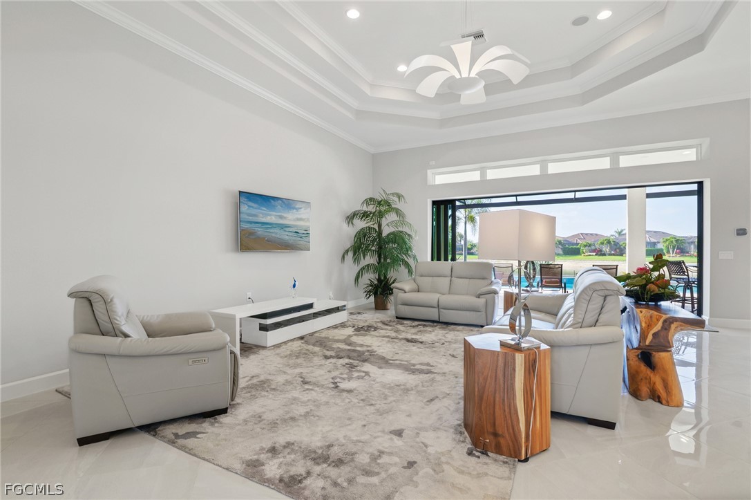 9345 Tulipano Terrace Naples, FL 34119 - Photo 5 of 50 a living room with furniture a chandelier and a dining table