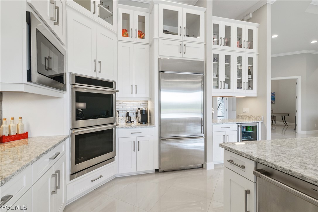 9345 Tulipano Terrace Naples, FL 34119 - Photo 8 of 50 a kitchen with stainless steel appliances granite countertop a refrigerator and a stove