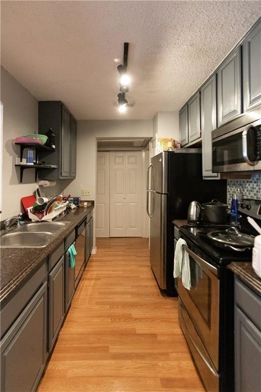 806 West 24th Street, Unit 314 Austin, TX 78705 - Photo 10 of 16 a kitchen with stainless steel appliances granite countertop a stove top oven a sink dishwasher a refrigerator and cabinets with wooden floor
