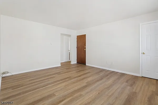 a view of an empty room with wooden floor