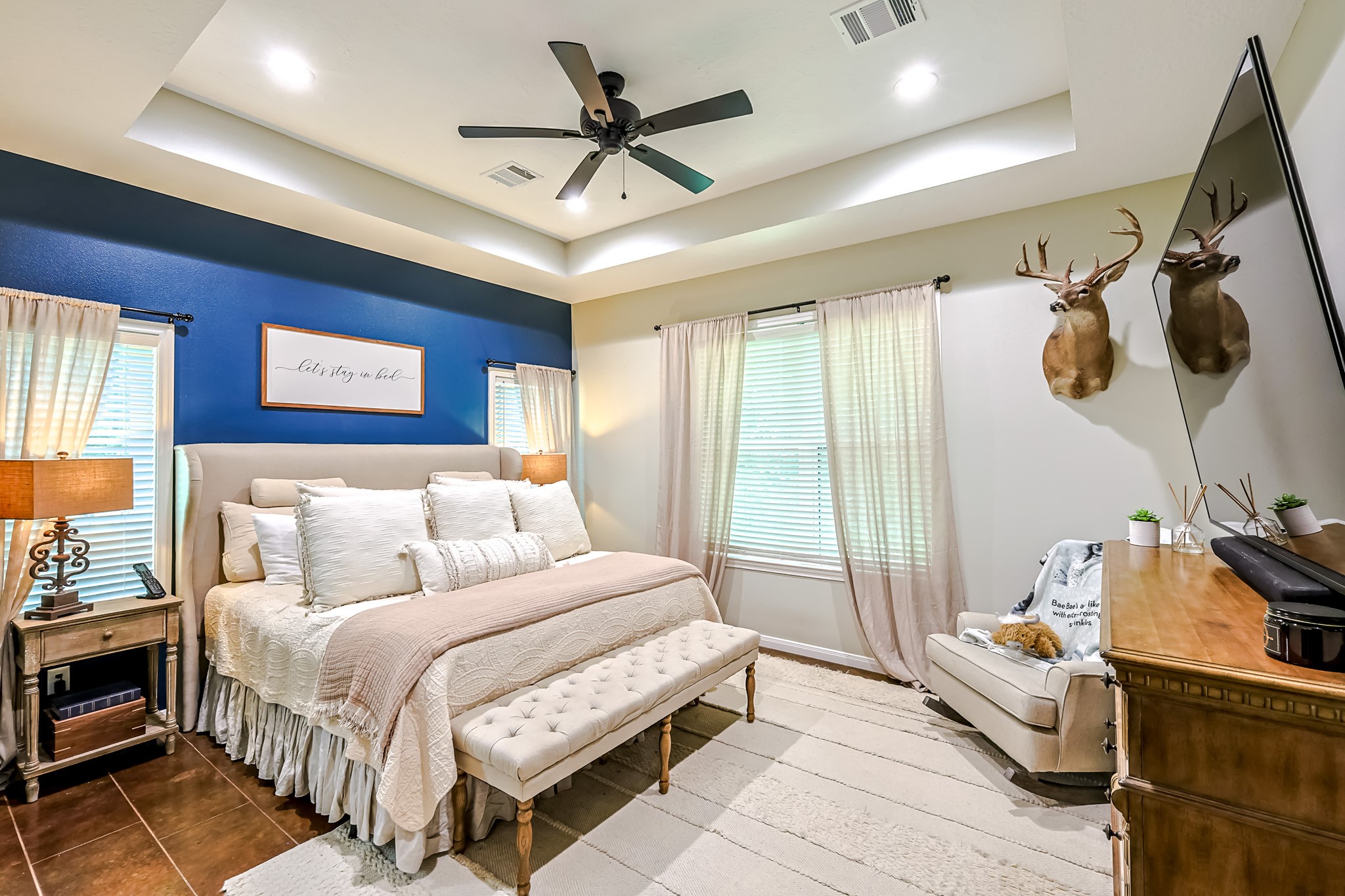 6409 Medley Road New Waverly, TX 77358 - Photo 20 of 50 This beautiful primary bedroom has a lovely accent walls, large windows, decorative ceiling and stained concrete floors.