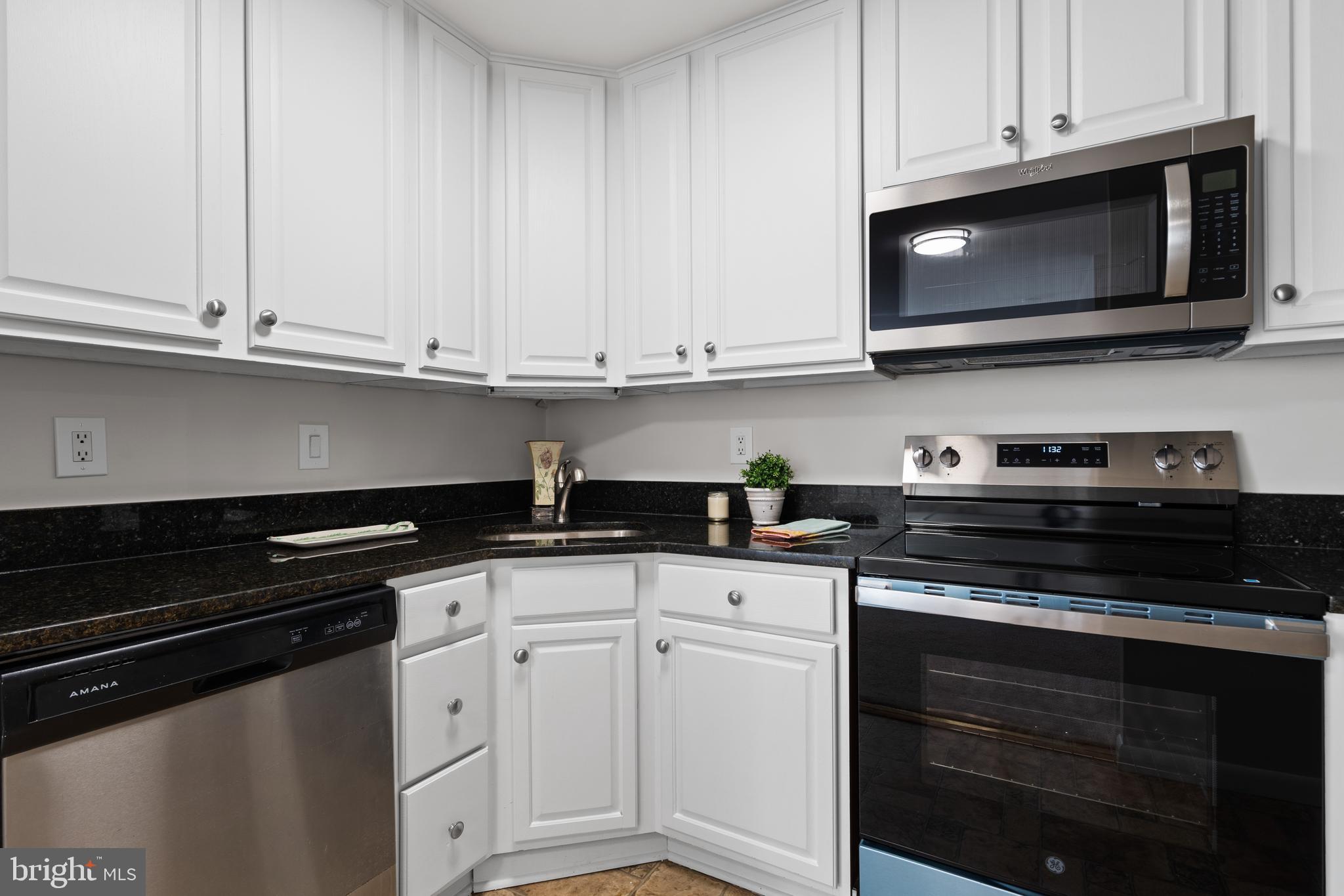 3245 Rio Drive, Unit 714 Falls Church, VA 22041 - Photo 14 of 30 a kitchen with granite countertop white cabinets and black appliances