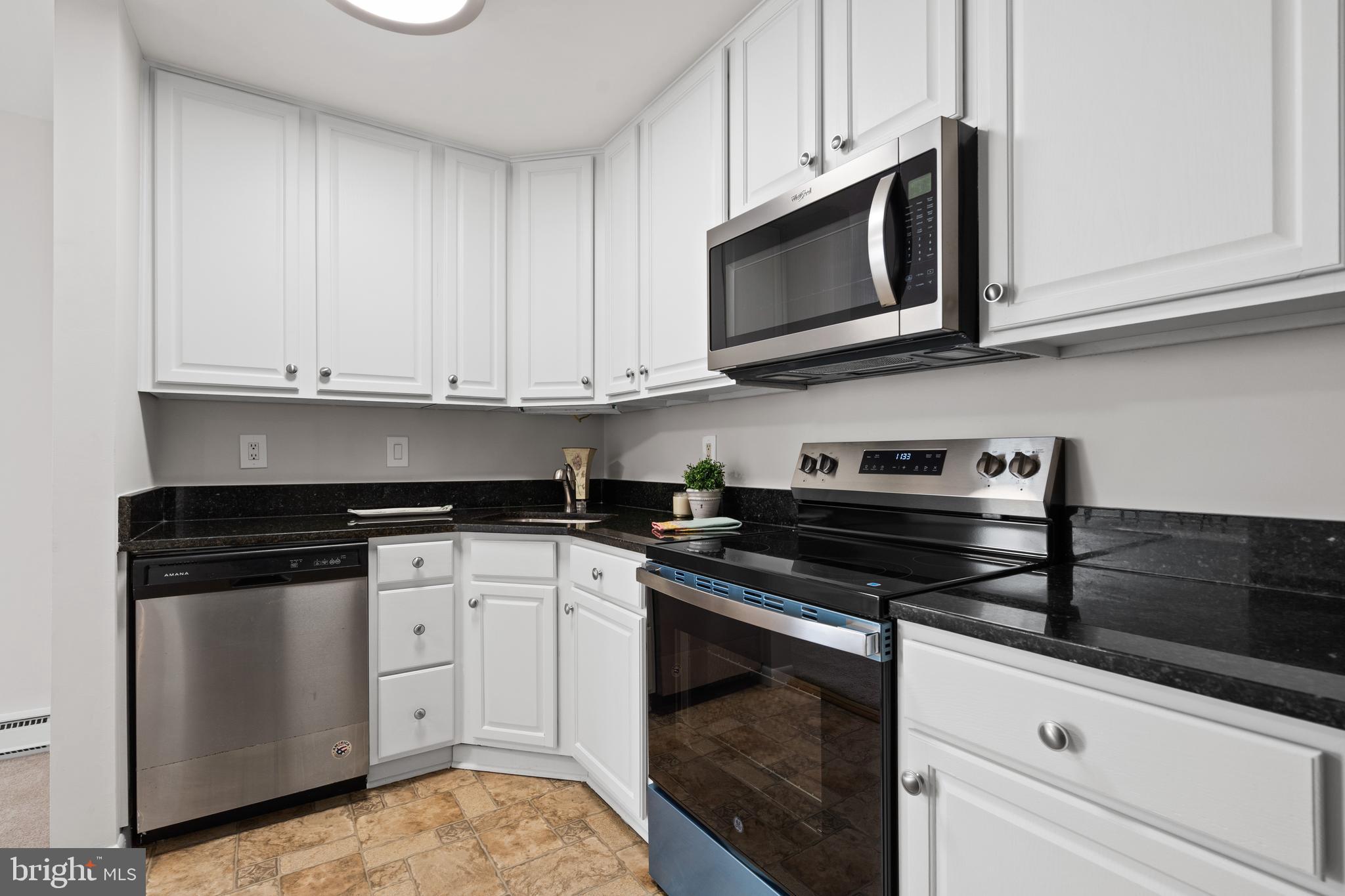 3245 Rio Drive, Unit 714 Falls Church, VA 22041 - Photo 16 of 30 a kitchen with stainless steel appliances granite countertop white cabinets and a stove a oven with white countertops