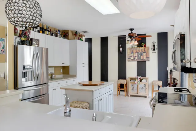 a kitchen with stainless steel appliances kitchen island granite countertop a refrigerator and a stove top oven