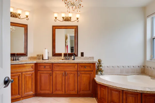 a bathroom with a granite countertop sink a large mirror and a bathtub