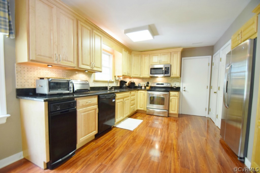 2301 Garrison Place Road Midlothian, VA 23112 - Photo 8 of 24 a kitchen with granite countertop wooden floors stainless steel appliances and a window