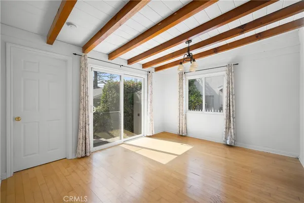 a view of a room with wooden floor and windows
