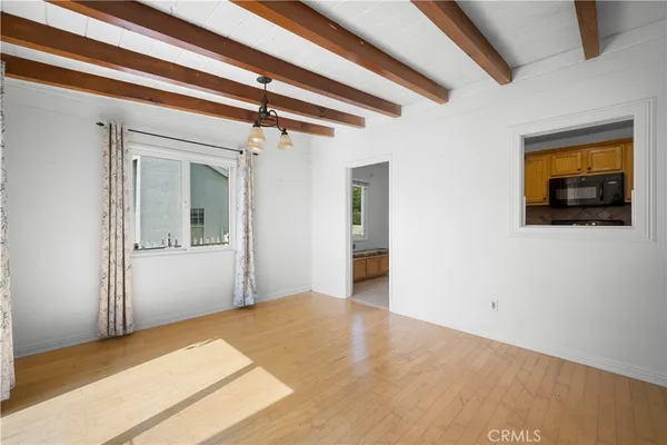 a view of a hallway with wooden floor and a ceiling fan