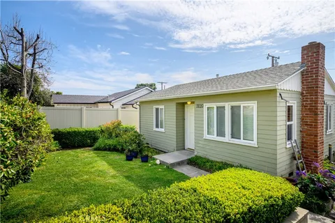 a view of backyard with potted plants and wooden fence