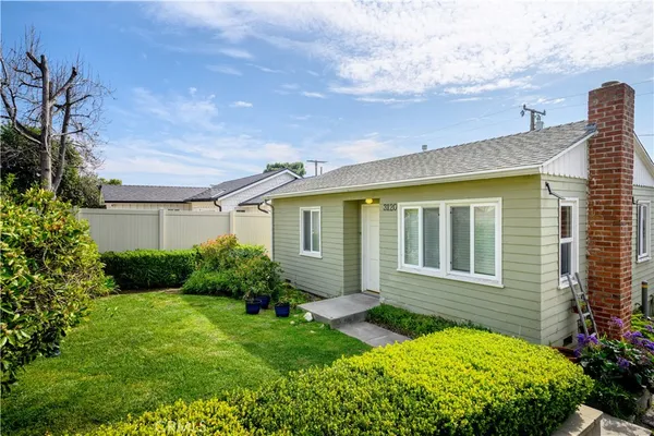 a view of backyard with potted plants and wooden fence