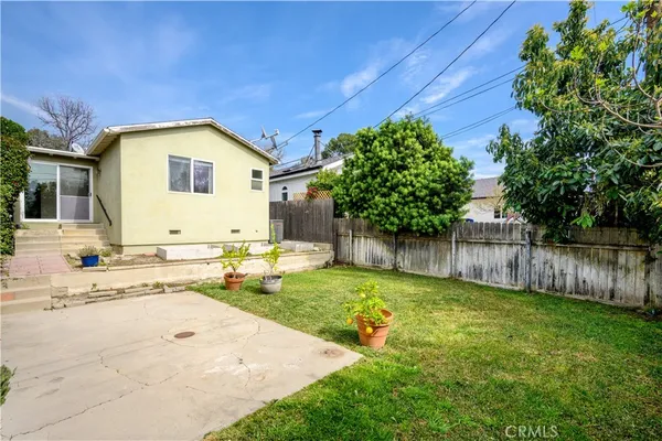 a view of a house with backyard and sitting area