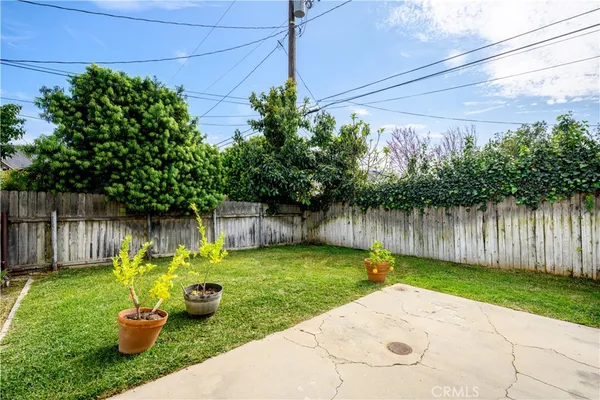 a backyard of a house with lots of green space and wooden fence