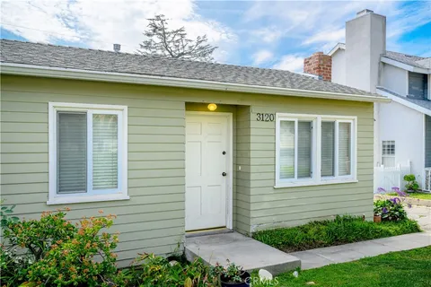 a front view of a house with plants
