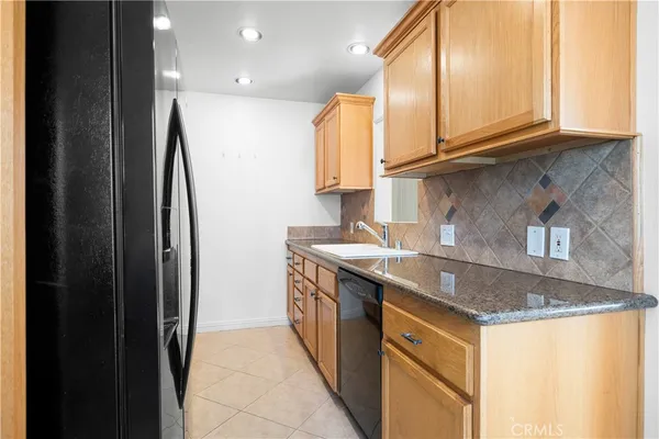 a kitchen with stainless steel appliances granite countertop a sink and a stove