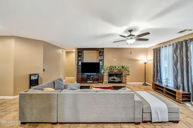 a living room with furniture a large rug and a view of kitchen
