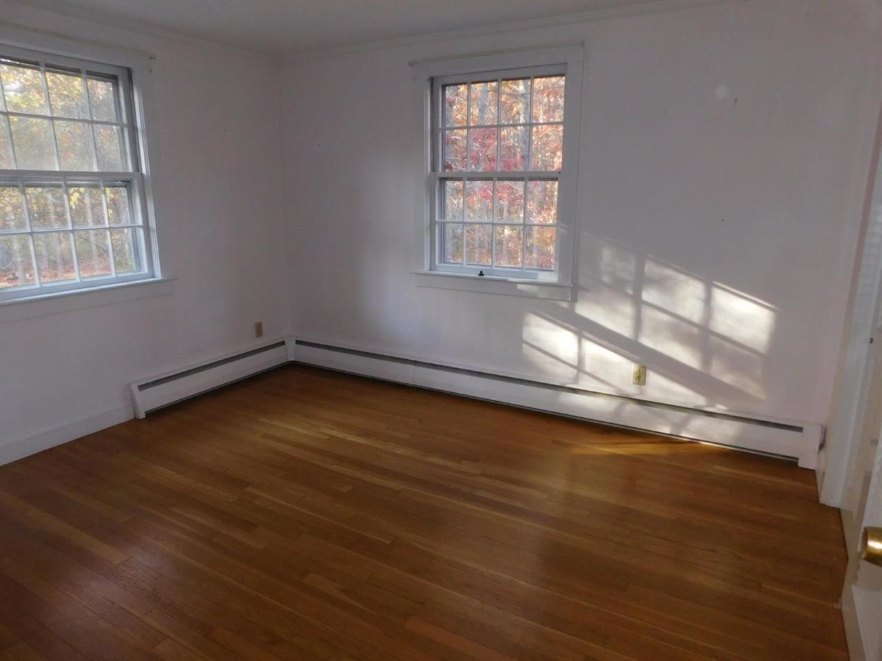 173 Lumbert Mill Road Centerville, MA 02632 - Photo 13 of 17 an empty room with wooden floor and windows