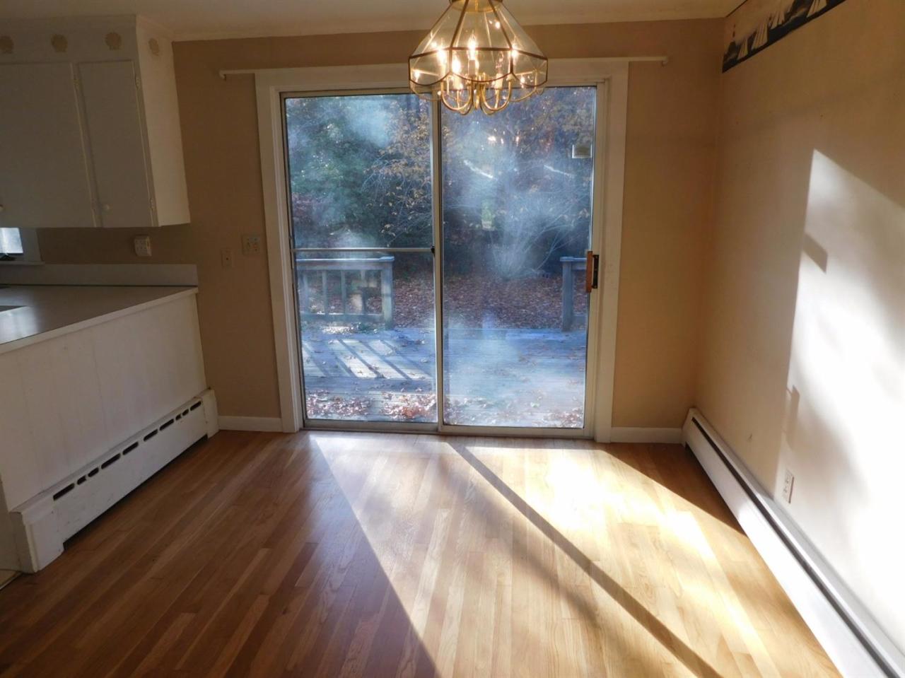 173 Lumbert Mill Road Centerville, MA 02632 - Photo 7 of 17 a view of a hallway with wooden floor and a kitchen space
