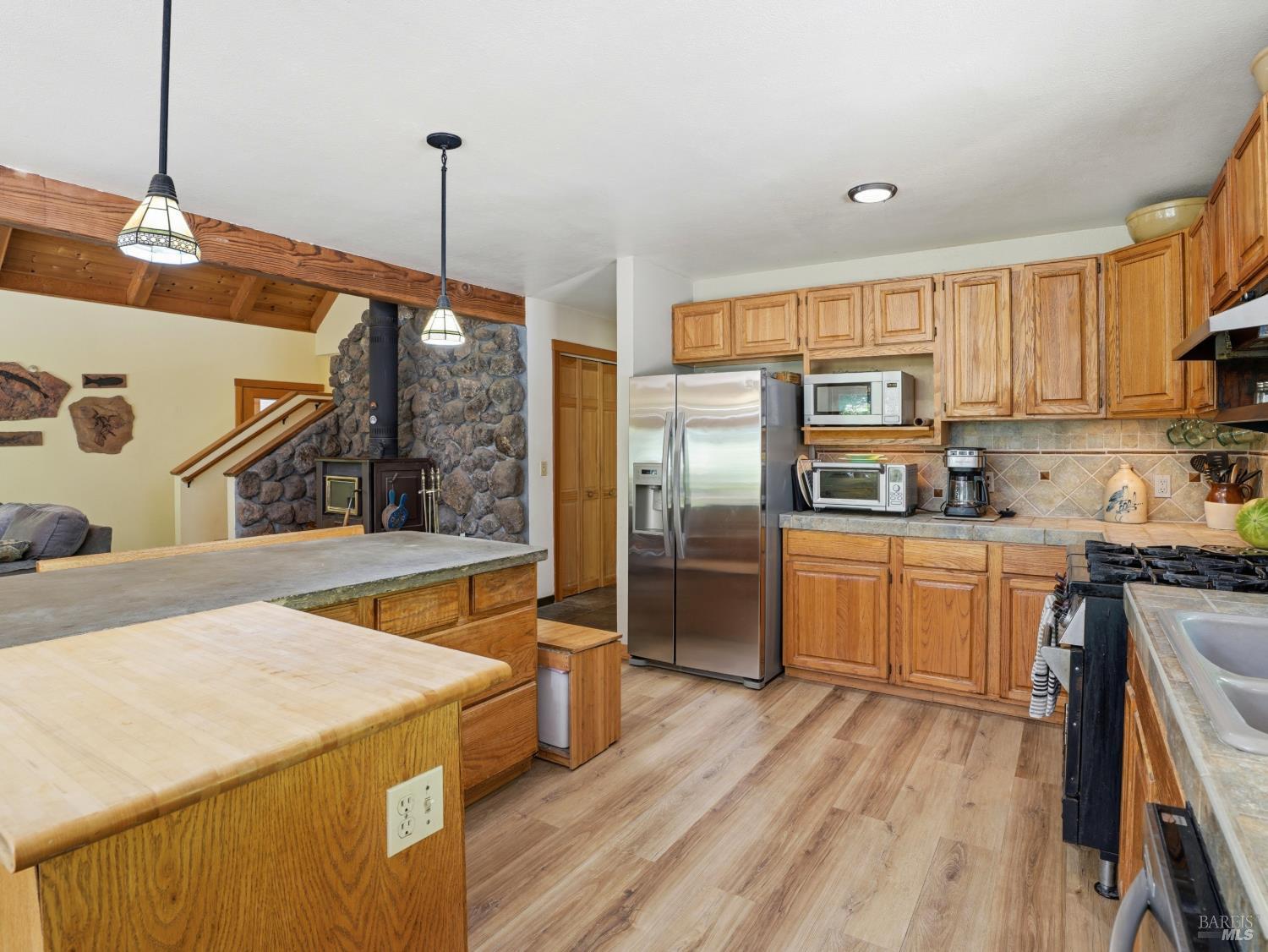 31397 Seaview Road Cazadero, CA 95421 - Photo 12 of 47 a kitchen with stainless steel appliances granite countertop a refrigerator a sink dishwasher a stove and white countertops with wooden floor
