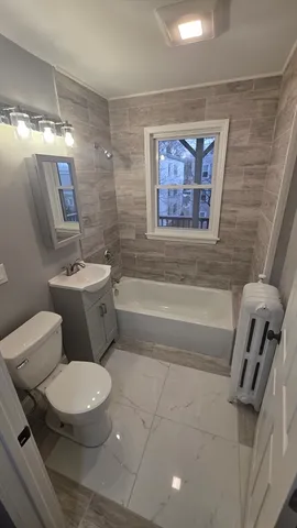 a white toilet sitting next to a bathroom sink and tub