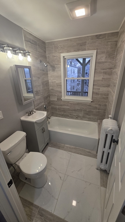 10 Itasca Street, Unit 3 Boston, MA 02126 - Photo 10 of 14 a white toilet sitting next to a bathroom sink and tub
