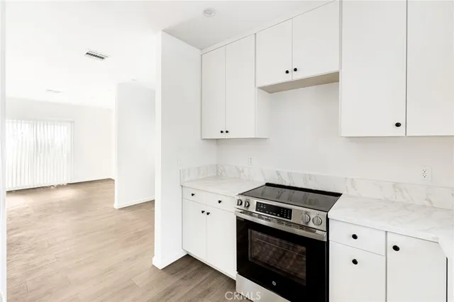 a kitchen with granite countertop white cabinets and white appliances