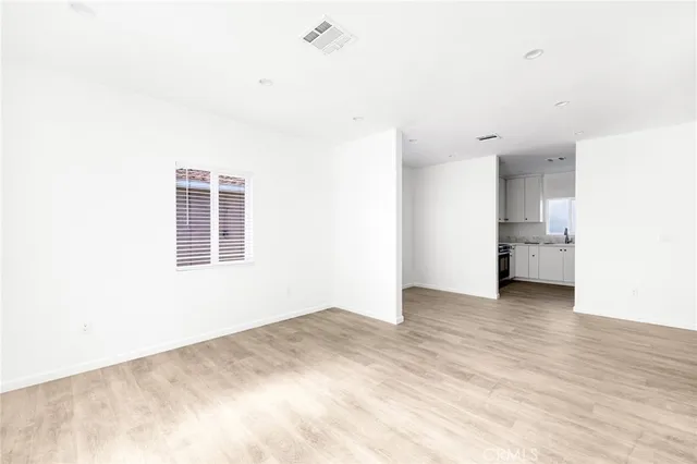 a view of empty room with wooden floor and entryway