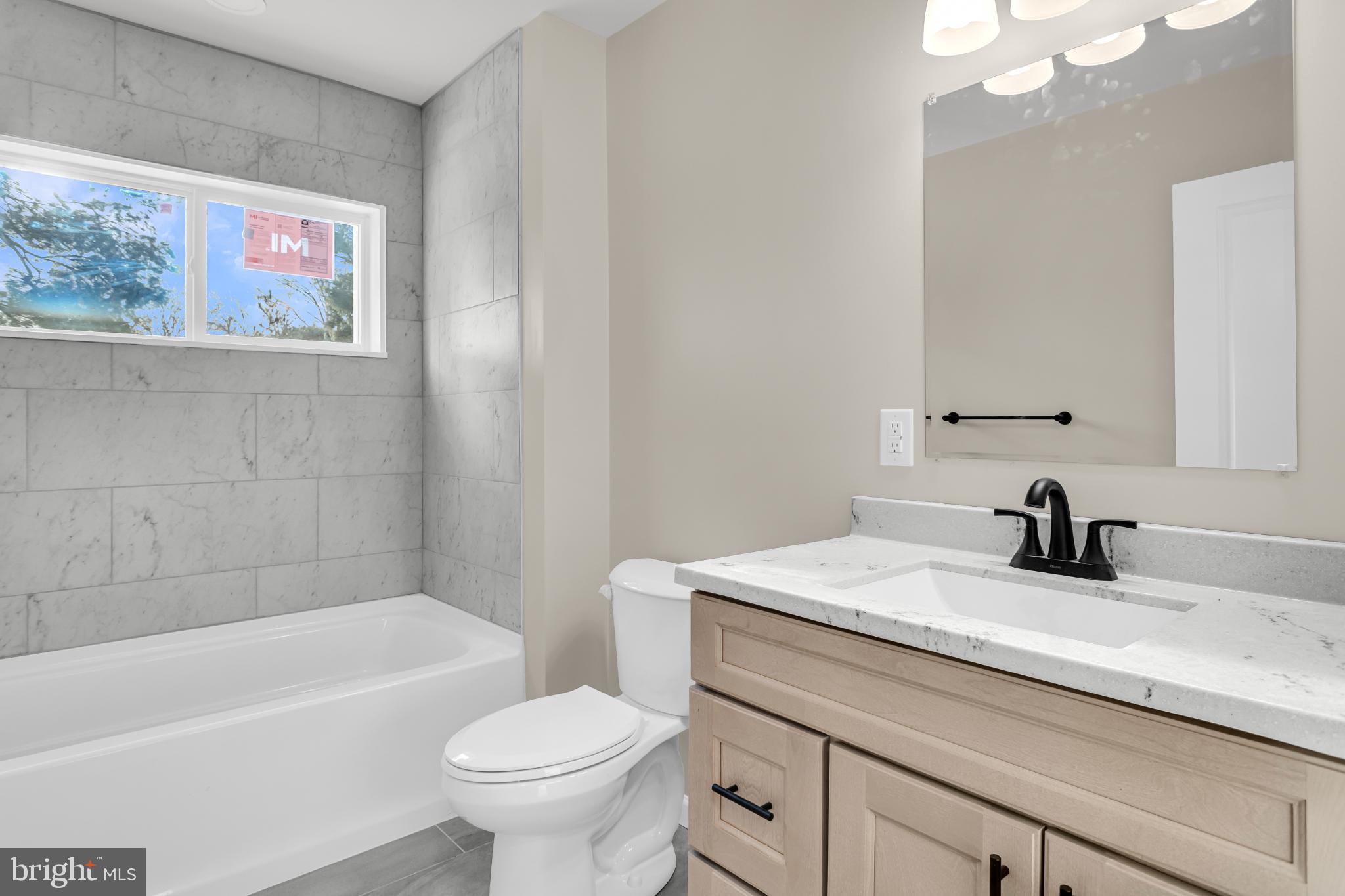 1716 Liggett Avenue Reading, PA 19607 - Photo 12 of 20 a bathroom with a granite countertop sink a toilet and a bathtub