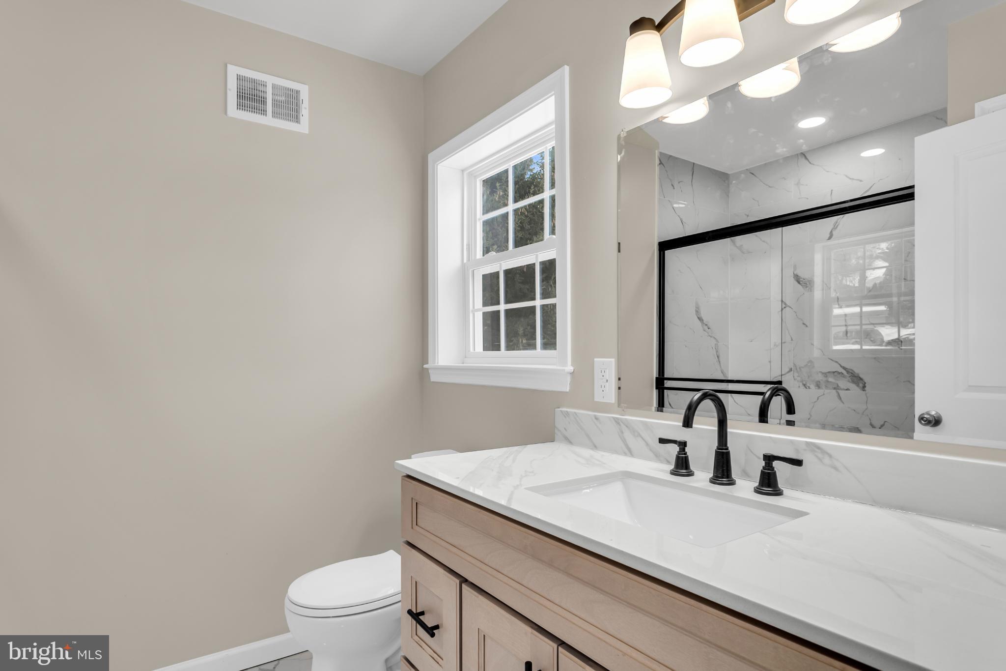 1716 Liggett Avenue Reading, PA 19607 - Photo 18 of 20 a bathroom with a granite countertop sink a toilet and a mirror