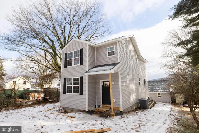 a front view of a house with a yard covered in snow