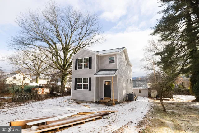 a view of a white house that has a tree in it