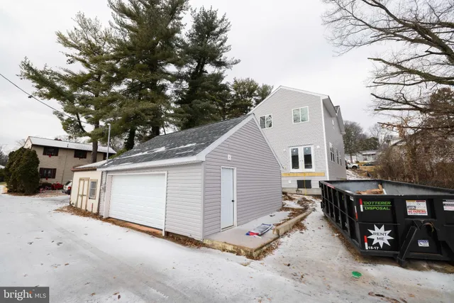 a view of a white house with a large tree in front of it