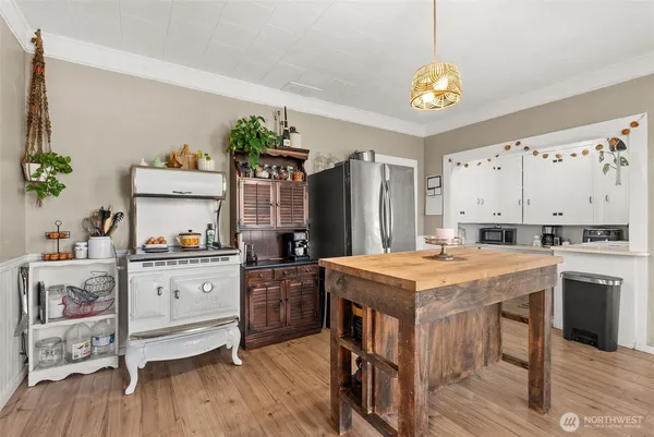 a kitchen that has a lot of cabinets a sink and wooden floor