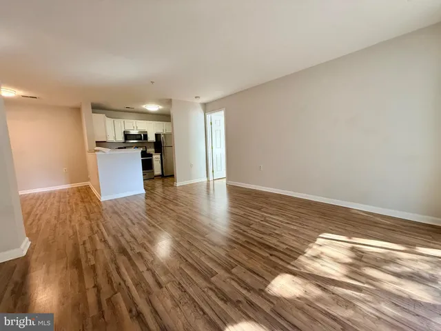 a view of a kitchen with wooden floor and electronic appliances