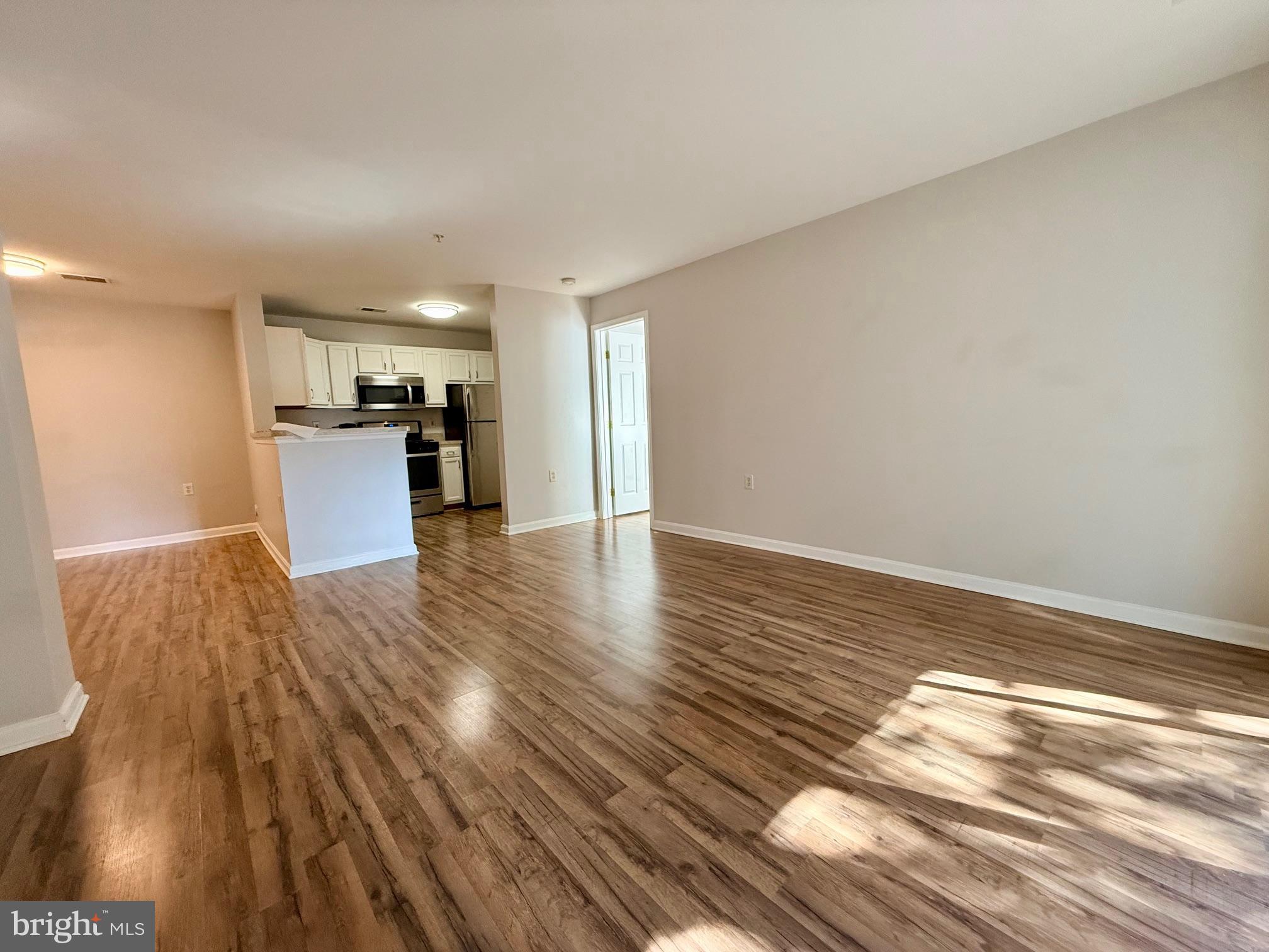 13621 Garfield Place, Unit 102 Woodbridge, VA 22191 - Photo 11 of 14 a view of a kitchen with wooden floor and electronic appliances