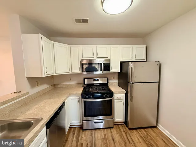 a kitchen with a refrigerator and a stove top oven