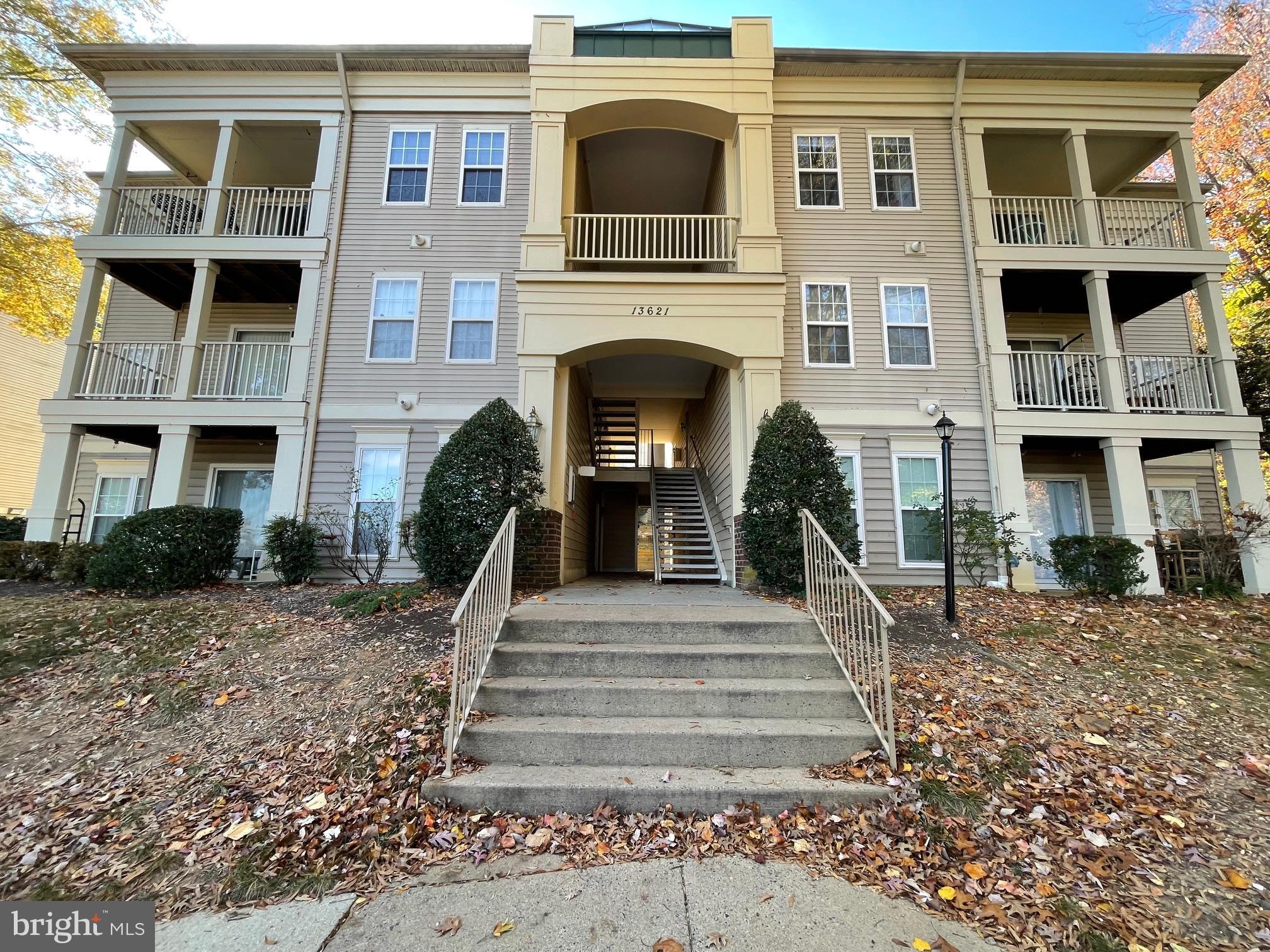 13621 Garfield Place, Unit 102 Woodbridge, VA 22191 - Photo 2 of 14 a front view of a house with a yard