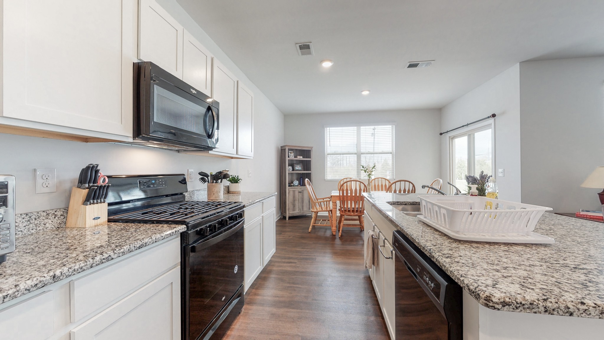 8012 Craighead Drive Lebanon, TN 37087 - Photo 11 of 53 a kitchen with stainless steel appliances granite countertop a stove top oven a sink dishwasher and a microwave with wooden floor