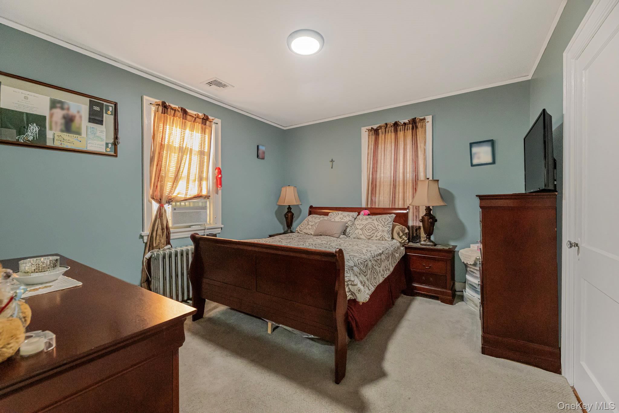 168 Stephenson Boulevard New Rochelle, NY 10801 - Photo 9 of 21 Bedroom featuring crown molding, light colored carpet, radiator, and cooling unit