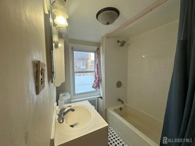 a bathroom with a tub sink and mirror